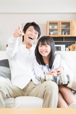 Asya aile evde televizyon izlerken