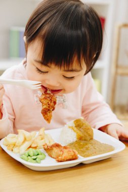 Güzel Asyalı kız evde Japon yemeği yiyor.