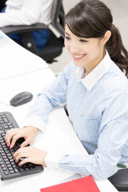 Bilgisayarda çalışan genç bir kadın.