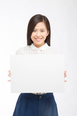 Beyaz arka planda boş kart gösteren güzel Japon iş kadınının stüdyo fotoğrafı. 