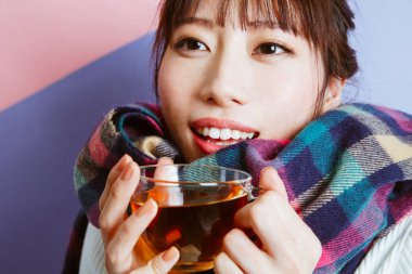 Genç Asyalı kız çay içiyor, stüdyo fotoğrafı. 