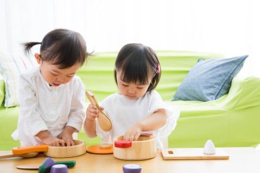 İki çocuk ahşap mutfak oyuncaklarıyla oynuyor.