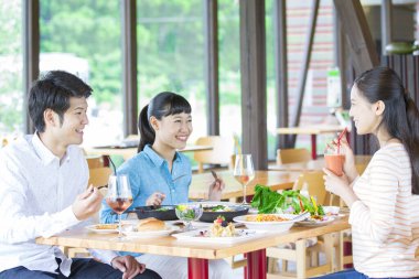 Asyalı arkadaşlar restoranda yemek yiyorlar. 