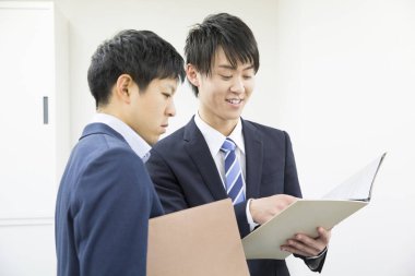 İki Asyalı iş adamı proje üzerinde birlikte çalışıyor.