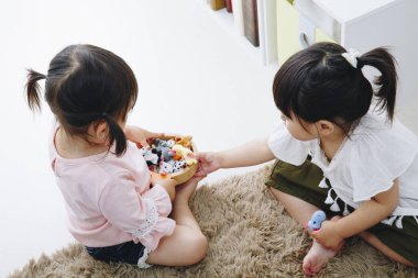 Asyalı çocuklar odada oynuyorlar. 