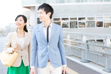 Genç Asyalı çift sokakta yürüyor.