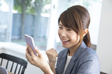 Kafede akıllı telefon kullanan genç Asyalı kadın.