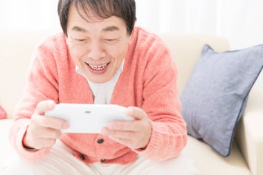 Evde video oyunu oynayan kıdemli adam.