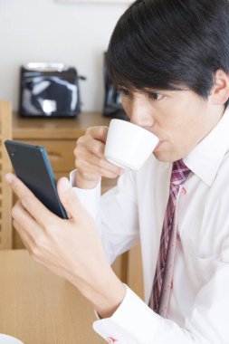 Btrakfast 'ta cep telefonu kullanan iş adamı 