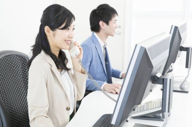 Genç Asyalı çalışanlar ofiste çalışıyor.