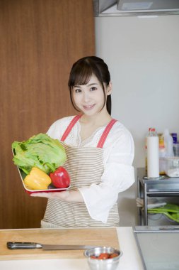 Mutfakta sebzeli genç Asyalı kadın. 