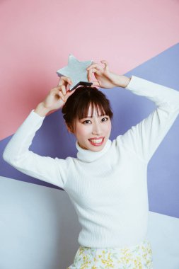 Stüdyo arka planında yıldız pozu veren kazaklı güzel bir kız.