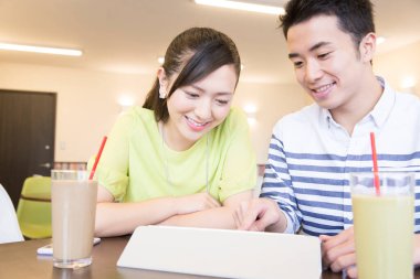 Kahve molasında tablete aşık Asyalı çift 