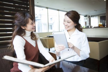 Güzel Japon garson restoranda tabletle sipariş veriyor.