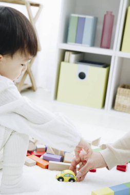 Evde annesiyle oynayan tatlı Asyalı kız.