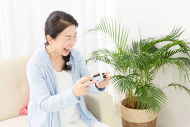 Yaşlı Asyalı kadın oyunlar oynuyor.