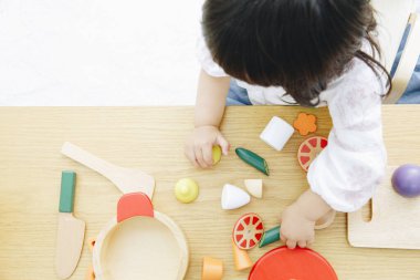 Evdeki oturma odasında oynayan tatlı Asyalı küçük kız.