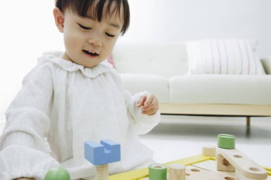 Evde oyuncaklarla oynayan sevimli Asyalı kız.