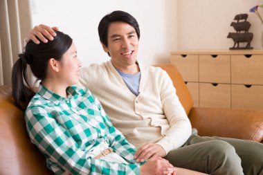 Oturma odasındaki kanepede oturan genç çift.