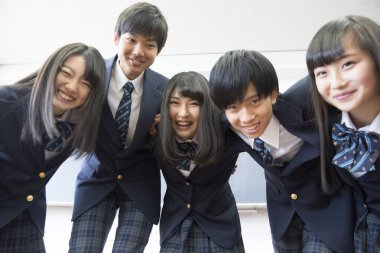 Sınıfta sarılan genç Japon öğrencilerin portresi.