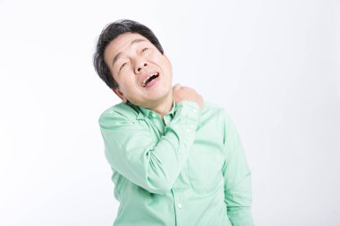  Beyaz arka planda sırt ağrısı çeken yaşlı bir Asyalı..