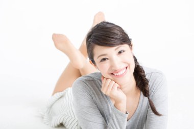 Mutlu Asyalı kadın yalan söylüyor, stüdyo fotoğrafı. 