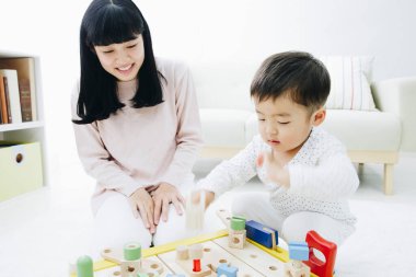 Evde annesiyle oynayan tatlı Japon çocuk.