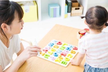 Renkli alfabe bulmacalı çocuk eğiten kadın