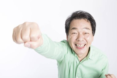 Beyaz arka planda yumruğu havada orta yaşlı Japon adam..