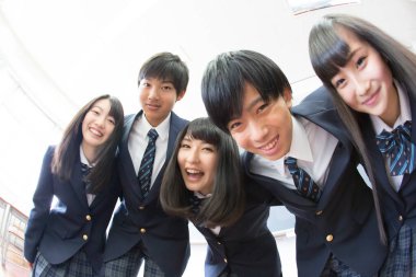 Sınıfta sarılan genç Japon öğrencilerin portresi.