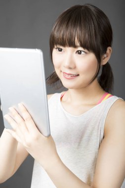 İzole edilmiş arkaplanda dijital tablet kullanan Asyalı kızın portresi