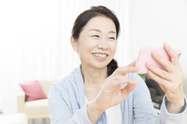 Kapat telefonu olan güzel, yaşlı Asyalı kadını.