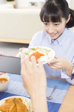 Güzel Asyalı bir kadının portresi öğle yemeği yiyor.