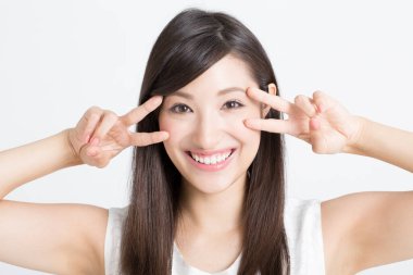 Beyaz arka planda V işaretleri gösteren güzel Asyalı kadın. 