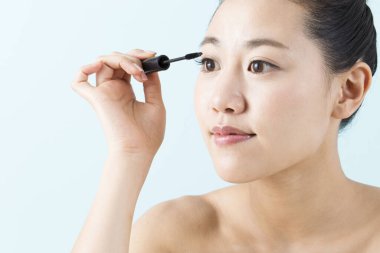 Maskara süren genç Asyalı kadın.