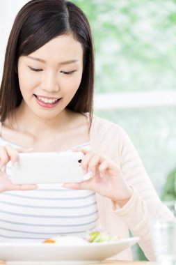 Yemek fotoğrafı çeken genç bir kadın. 