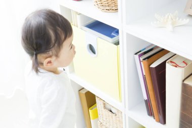 Evdeki oturma odasında oynayan küçük tatlı bir Japon kız.