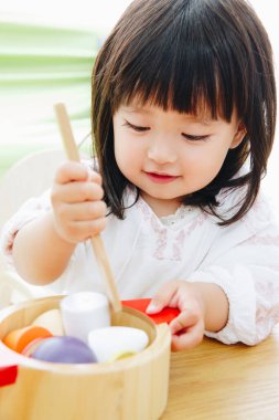 Evdeki oturma odasında oynayan tatlı Asyalı küçük kız.