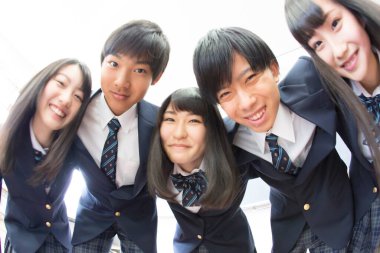 Sınıfta sarılan genç Japon öğrencilerin portresi.