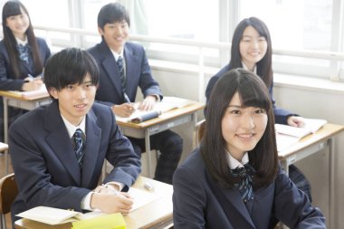 Genç Japon öğrenciler sınıfta okuyor.