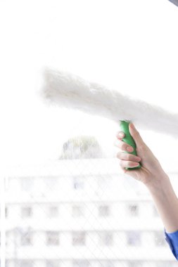 Kadın elleri pencereyi temizliyor. 