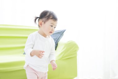 Evdeki oturma odasında oynayan küçük tatlı bir Japon kız.