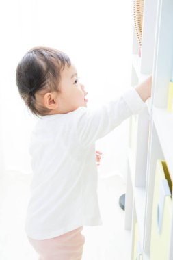 Evdeki oturma odasında oynayan küçük tatlı bir Japon kız.