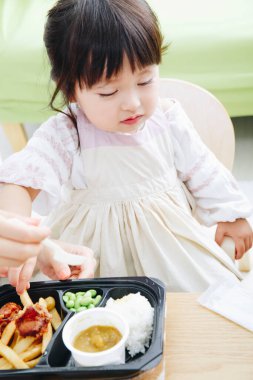 Şirin Asyalı küçük kız. Restoranda yemek yiyor.