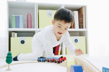 Şirin Japon çocuk evde oyuncaklarla oynuyor.