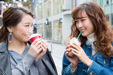 İki Asyalı kadın kahve içiyor.