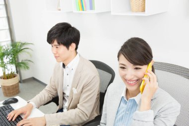 İş yerinde Asyalı iş kadınının akıllı telefonuyla konuştuğu portre. 