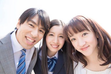 Kamerada gülümseyen Asyalı öğrenciler ve öğretmen  