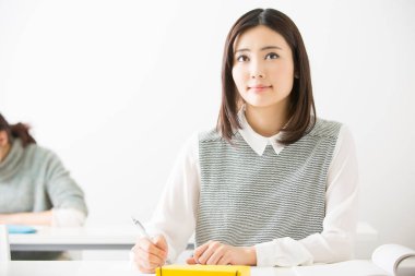 Sınıftaki Asyalı kadın öğrenci.