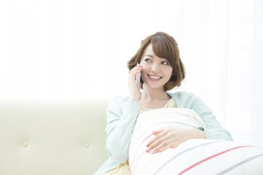 Evde cep telefonu kullanan bir kadın